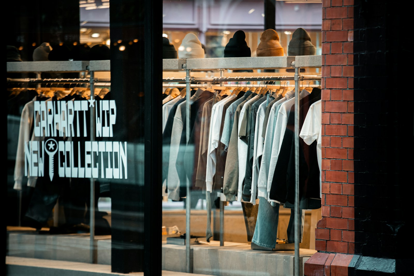 Clothes displayed on racks inside a bright store window